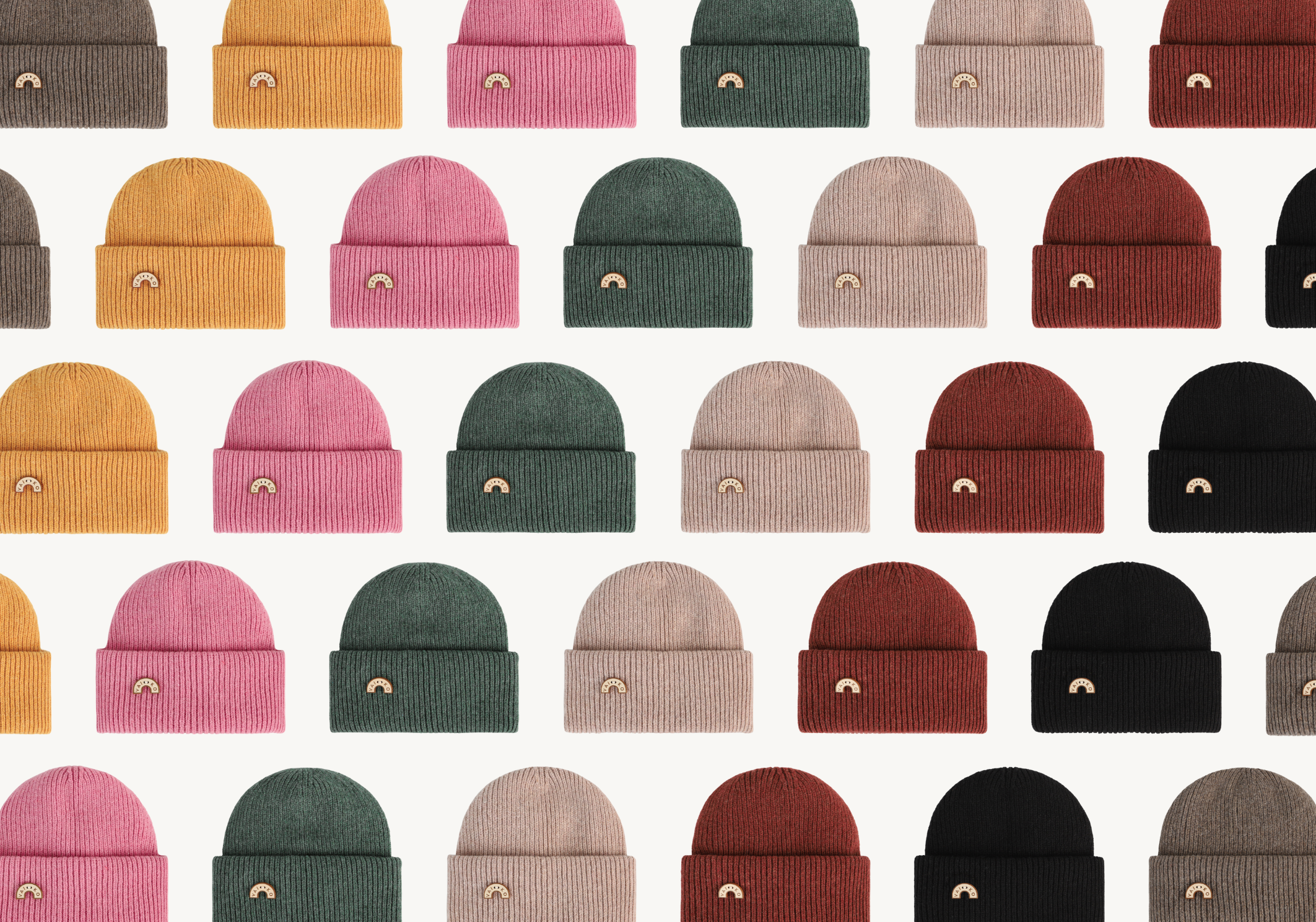 Pattern of colorful knit beanies arranged in rows on a white background; various colors include pink, green, and yellow.