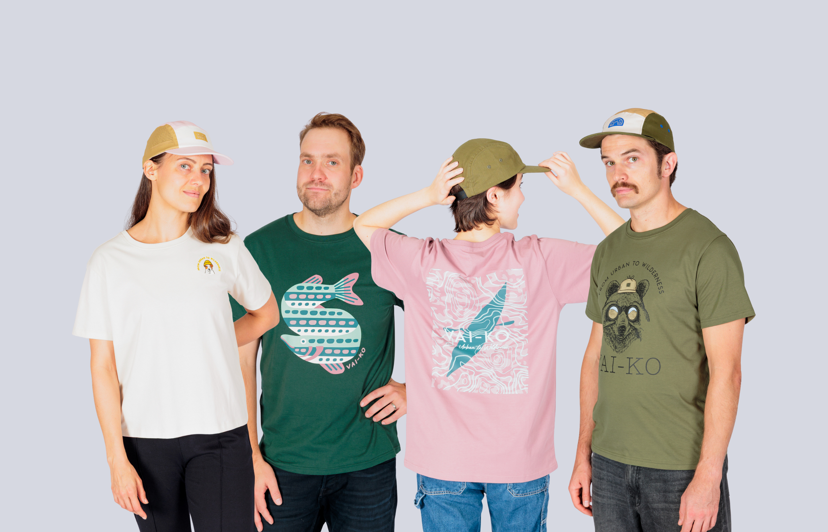 Man in an olive green graphic t-shirt and cap standing against a plain light gray background.