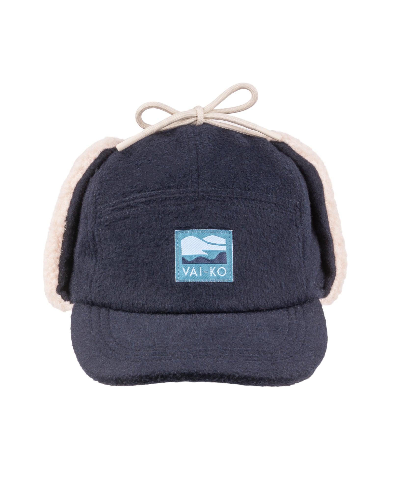Navy blue fleece cap with ear flaps, a front patch reading VAI-KO, and a bow on top.